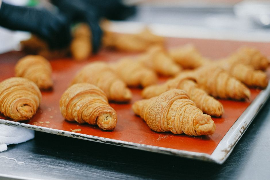 Close-up of golden croissants fresh out of the oven on a baking tray.